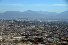 
Vancouver Stretches To Downtown And Mountains Beyond From Airplane
